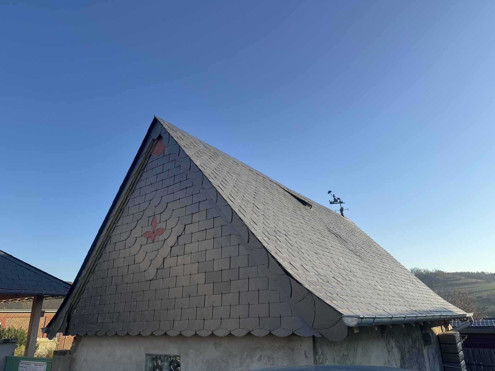 Pose d'ardoise avec motifs décoratifs sur pignon